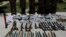 FILE - Weapons and ammunition seized are presented to the media along with insurgents suspected of being from the Haqqani network at the National Directorate of Security (NDS) headquarters in Kabul, May 30, 2013.