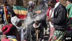 Warga merokok ganja di luar Mahkamah Konstitusi di Johannesburg saat pengadilan tinggi Afrika Selatan bersidang untuk melegalisasi konsumsi ganja untuk keperluan pribadi, 18 September 2018.