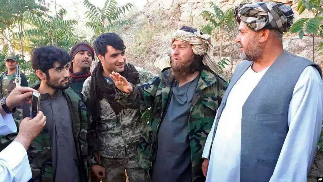 A foreign Islamic State group fighter (2nd-R) speaks to a journalist after he surrendered to government security forces in the Darzab district of Jawzjan province, north of Kabul, Afghanistan, Aug. 1, 2018. 