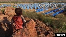FILE - A boy sits atop a hill overlooking a refugee camp near the Chad-Sudan border, November 9, 2023. Hundreds of Masalit families from Sudan's West Darfur state were relocated months after fleeing an ethnically targeted massacre in the city of El Geneina. 
