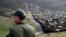 FILE - Border Patrol agent Vincent Pirro looks on near a border wall that separates the cities of Tijuana, Mexico, and San Diego, Feb. 5, 2019, in San Diego, California. 