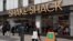 FILE - People walk past a Shake Shack restaurant, in New York. 