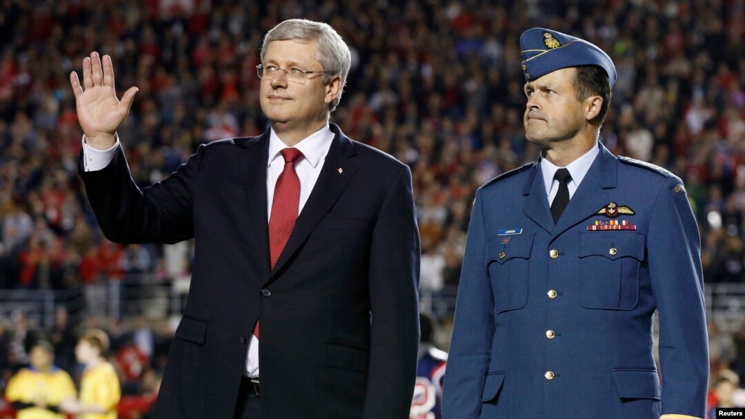 Perdana Menteri Kanada Stephen Harper (kiri) dan Kepala Staf Umum Pertahanan Kanada Tom Lawson ikut dalam sebuah tribute untuk tentara Kanada yang tewas tertembak, sebelum pertandingan football CFL antara Ottawa Redblacks dan Montreal Alouettes di Ottawa.