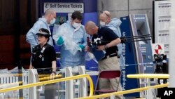 Forensic officers investigate the scene near the Manchester Arena, Manchester, England, May 23, 2017, the day after the suicide attack at an Ariana Grande concert that left 22 people dead as it ended on Monday night.