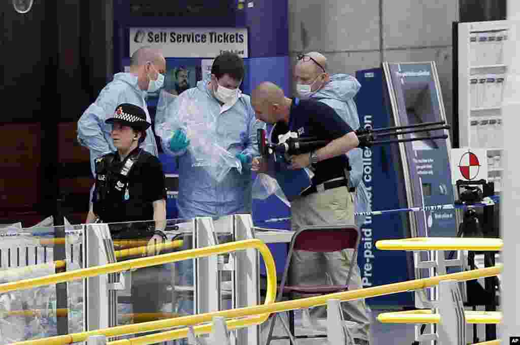 Forensic officers investigate the scene near the Manchester Arena, Manchester, England, May 23, 2017, the day after the suicide attack at an Ariana Grande concert that left 22 people dead as it ended on Monday night.