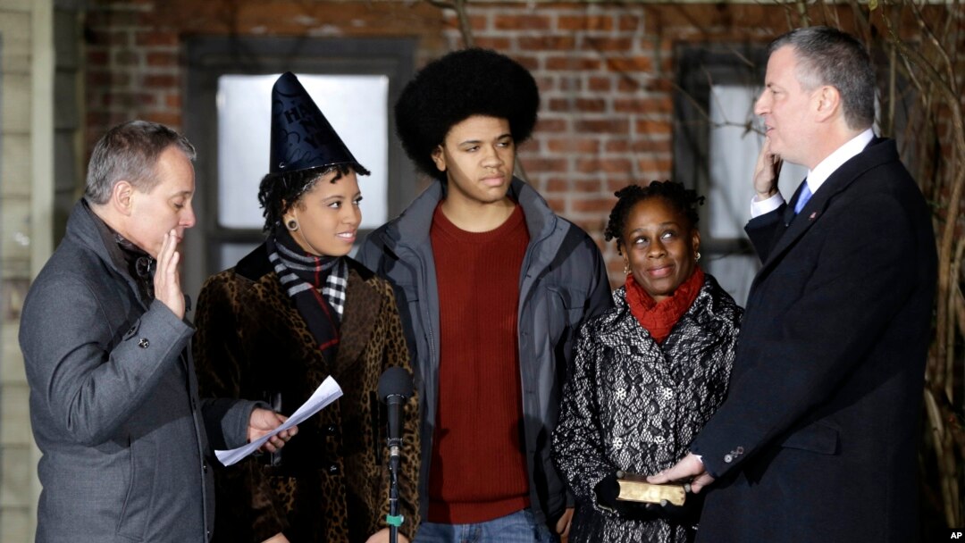 Bill de Blasio (kanan) disumpah sebagai walikota New York City oleh Jaksa Agung Eric Schneiderman (kiri), disaksikan keluarganya. (AP/Seth Wenig)