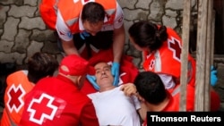 A reveler is helped by medical staff during the running of the bulls at the San Fermin festival in Pamplona, Spain, July 14, 2019.