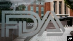 FILE - This Aug. 2, 2018, photo shows the U.S. Food and Drug Administration building behind FDA logos at a bus stop on the agency's campus in Silver Spring, Maryland.