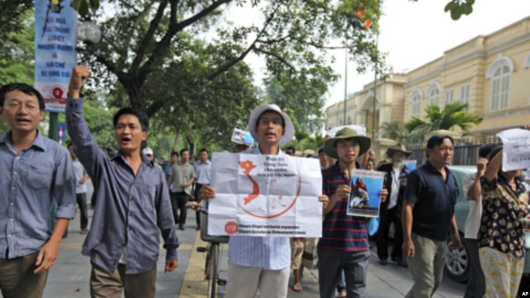 Protesters hold anti-China placards to protest what they say is aggressive action by China in the dispute over a resource-rich area in the South China Sea, while marching near the Chinese embassy in Hanoi, Vietnam, July 10, 2011