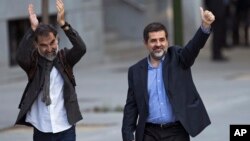 Los dirigentes Jordi Cuixart, izquierda, y Jordi Sánchez, saludan a sus simpatizantes a la llegada a un tribunal en Madrid. Posteriormente fueron encarcelados.