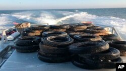 This Oct. 12, 2017, photo provided by the California Coastal Commission/UC Davis shows a pile of scrap tires after they were pulled out of the water off Balboa Peninsula in Newport Beach, Calif. Divers are removing hundreds of old tires, plastic jugs and other junk that were dumped off the Southern California coast nearly 30 years ago in hopes of creating an artificial reef that would serve as a home to fish and mussels. (California Coastal Commission/UC Davis via AP)