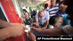 Ciudadanos venezolanos obtienen identificaciones que les permitirán votar este domingo en las elecciones presidenciales.