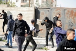 جنین میں 26 جنوری کو اسرائیلی فوجیوں کے ساتھ مسلح تصادم کے دوران فلسطینی نوجوان پتھراؤ کر رہے ہیں : فوٹو رائٹرز۔ 26 جنوری 2023