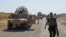 FILE - Military vehicles of Iraqi security forces on a road during clashes with Islamic State (IS) militants in the Hamrin mountains in Diyala province.