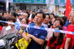 Parents wait behind police cordon outside the venue for the annual national college entrance examination, or "gaokao", in Shenyang, Liaoning province, China, June 7, 2018.