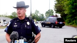 Cobb County police spokesman Sergeant Dana Pierce gives a briefing at the scene of a shooting at a FedEX Corp facility at an airport in Kennesaw, Georgia April 29, 2014.