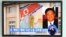 Passersby watch a local television broadcast in Seoul on May 2, 2013 showing a report and picture of Kenneth Bae (R), a Korean-American tour operator detained in North Korea, against the background of a North Korean flag painted on the wall of a building 