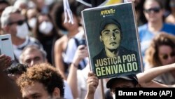 Poster com mensagem "Justiça para Genivaldo" durante protesto pela morte for asfixia de um homem negro por dois polícias, Rio de Janeiro, a 28 Maio 2022