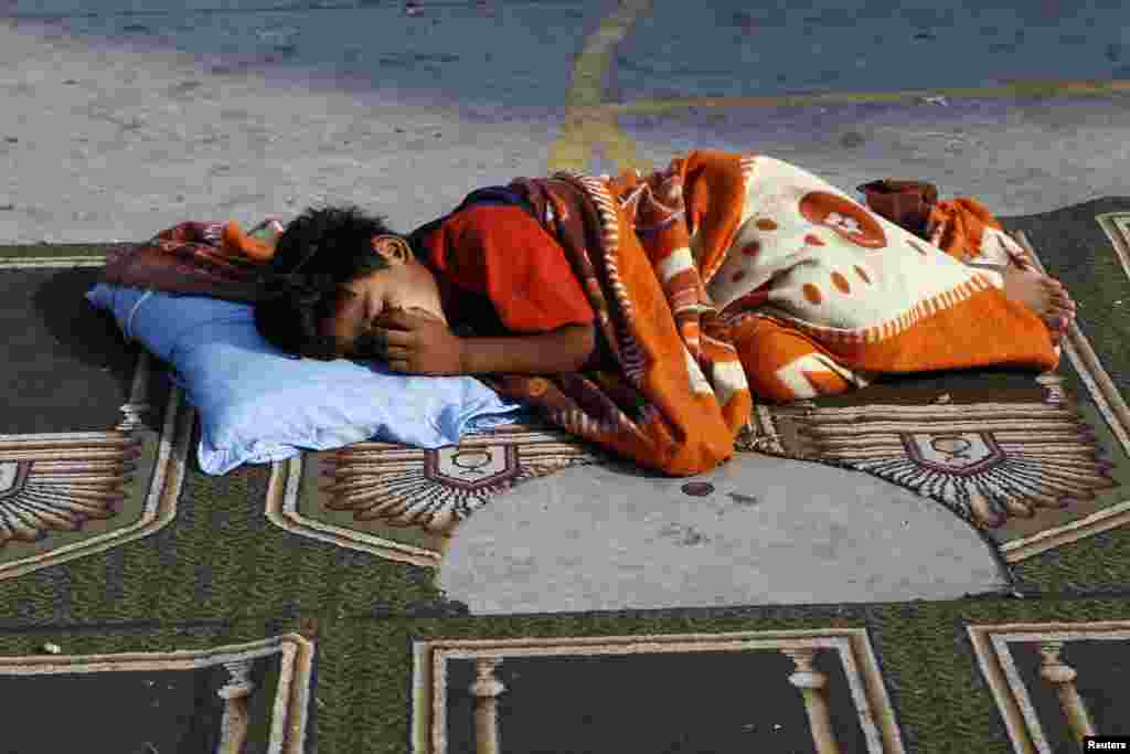 A boy sleeps in a United Nations-run school sheltering displaced Palestinians in Gaza City, August 8, 2014.
