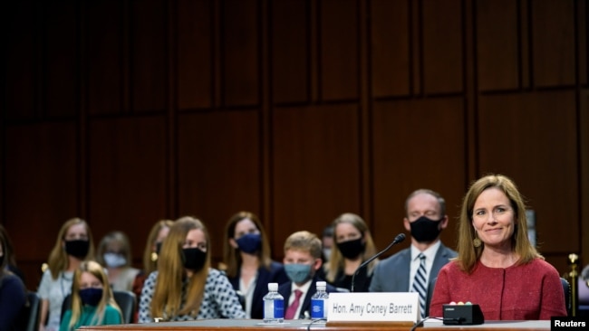 U.S. Supreme Court nominee Judge Amy Coney Barrett reacts as she sits in front of her children and her husband Jesse Barrett during the second day of her confirmation hearing before the Senate Judiciary Committee on Capitol Hill in Washington, D.C.