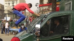 Seorang demonstran melompat ke mobil polisi yang lewat dalam protes anti-pemerintah (22/2). (Foto: Reuters)