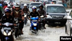 Pengendara motor mengarungi banjir di Jakarta. (Foto: Dok)