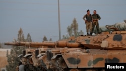 Turkish soldiers stand on top of a tank in the border town of Akcakale in Sanliurfa province, Turkey, Oct. 11, 2019. 