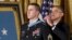 President Barack Obama bestows the Medal of Honor, to Ryan M. Pitts, 28, a former Army staff sergeant who fought off enemy fighters during one of the bloodiest battles of the Afghanistan war despite his own critical injuries, in the East Room of the White