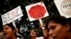 FILE - Indian physiotherapy students hold placards at a rally on the first anniversary of the fatal gang rape of a young woman in a bus New Delhi, India, Dec. 16, 2013.