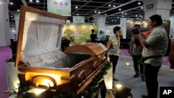Visitors look at a paper casket at the Asia Funeral and Cemetery Expo & Conference in Hong Kong, May 18, 2017. Asia's aging population is projected to hit 923 million by midcentury, according to an Asian Development Bank, putting the region on track to be