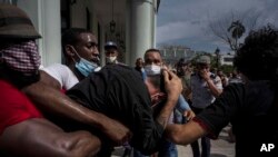 Para polisi tak berseragam tampak menahan seorang demonstran dalam aksi protes yang berlangsung di Havana, Kuba, pada 11 Juli 2021. (Foto: AP/Ramon Espinosa)