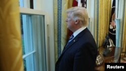 U.S. President Donald Trump looks out a window of the Oval Office following an interview with Reuters at the White House in Washington, April 27, 2017.