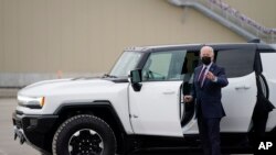 প্রেসিডেন্ট জো বাইডেন ডেট্রয়েট, মিশিগানে, জেনারেল মোটর্সের কারখানাতে টেস্ট ড্রাইভের জন্য বিদ্যুৎ চালিত হামার গাড়িতেট উঠছেন। ১৭ নভেম্বর ২০২১। (ছবি-এপি/ইভান ভুচ্চি) 