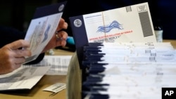 FILE - An election worker processes mail-in and absentee ballots in West Chester, Pennsylvania, Nov. 4, 2020. While there's already been a steady buildup of influence operations in the run-up to the November polls, the worst may be yet to come, officials and experts warn.