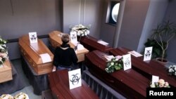 Biohazard warning signs are placed on the coffins of people who died of the coronavirus disease (COVID-19), at a mortuary near the city of Charleroi, Belgium April 7, 2020.