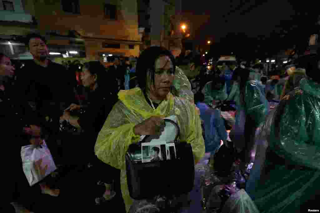 Mourners wear rain covers as they wait to attend the Royal Cremation ceremony of Thailand's late King Bhumibol Adulyadej near the Grand Palace in Bangkok, Thailand October 24, 2017. REUTERS/Kerek Wongsa - RC14634A6000