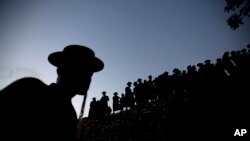 Para pria Yunani Ultra-Orthodox antri mengambil air untuk membuat matza, roti khusus yang dibuat untuk perayaan Paskah, di dekat Yerusalem (21/4).