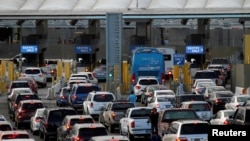 FILE - Cars stand in multiple lines as they wait to be inspected by U.S. Border Patrol officers to enter from Mexico to the U.S. as the San Isidro point of entry in Tijuana, Mexico, Apr. 4, 2018.