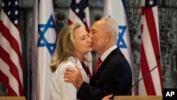 ARSIP - Mantan Menlu AS, Hillary Clinton, kiri dan Shimon Peres, berpelukan setelah mengeluarkan pernyataan bersama (16/7/2012). (foto: AP Photo/Oded Balilty).