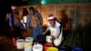 FILE - Residents collect water at night from an electric-powered well, as the country faces 18-hour daily power cuts, in a suburb of Harare, Zimbabwe, July 30, 2019.