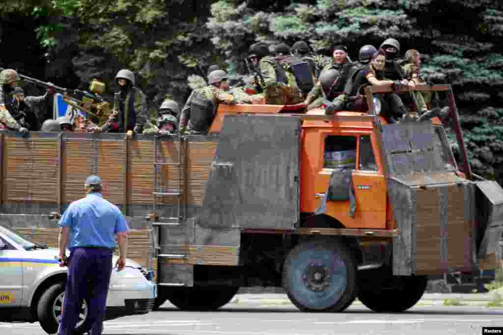 Ukrainian troops ride on the back of a truck near the site of fighting, Mariupol, June 13, 2014.&nbsp;