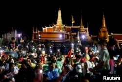 Pro-democracy protesters light up their mobile phones as they attend a mass rally to call for the ouster of Prime Minister Prayuth Chan-ocha's government and reforms in the monarchy, in Bangkok, Thailand, Sept. 19, 2020.