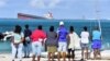 Des Mauriciens regardent le vraquier MV Wakashio échoué près du parc marin de Blue Bay dans le sud-est de l'île Maurice le 6 août 2020.