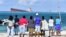 Des Mauriciens regardent le vraquier MV Wakashio échoué près du parc marin de Blue Bay dans le sud-est de l'île Maurice le 6 août 2020.
