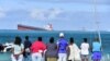 Des spectateurs regardent le vraquier Wakashio qui s'est échoué et dont le pétrole fuit près du parc marin de Blue Bay, dans le sud-est de l'île Maurice, le 6 août 2020. (Photo by Dev Ramkhelawon / L'Express Maurice / AFP)