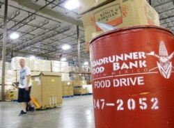 FILE - A volunteer moves a pallet of food for low-income families at the Roadrunner Food Bank in Albuquerque, N.M., June 21, 2013.