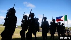 FILE - Soldiers march at Guiuan airport to take part in the welcoming ceremony for visiting French President Francois Hollande in Guiuan, Samar, a town that was devastated by Typhoon Haiyan in central Philippines, February 27, 2015.