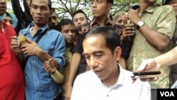 Capres Jokowi dikawal petugas berseragam batik saat berkunjung ke Pasar Barang bekas, Notoharjo, Solo, akhir pekan lalu. (VOA/Yudha Satriawan)