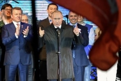 FILE - Russian President Vladimir Putin addresses the crowd during a concert marking the fifth anniversary of Russia's annexation of Crimea, in Simferopol, March 18, 2019.