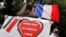 A supporter of police, wearing a protective face mask, holds a banner as she demonstrates in front of the French police headquarters in Paris, June 27, 2020. The banner reads: "Total support for police forces." 